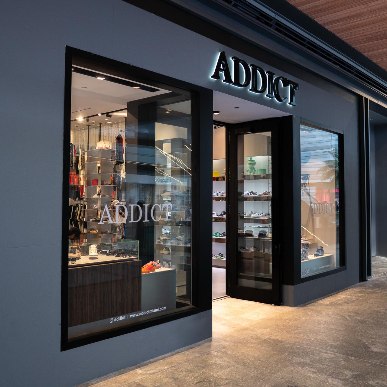 The illuminated ADDICT sign above the Brickell City Centre storefront at dusk